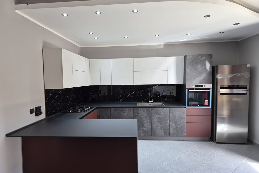 Composizione cucina cemento grigio/pensili bianchi opachi e elementi rosso Marsala con penisola snack