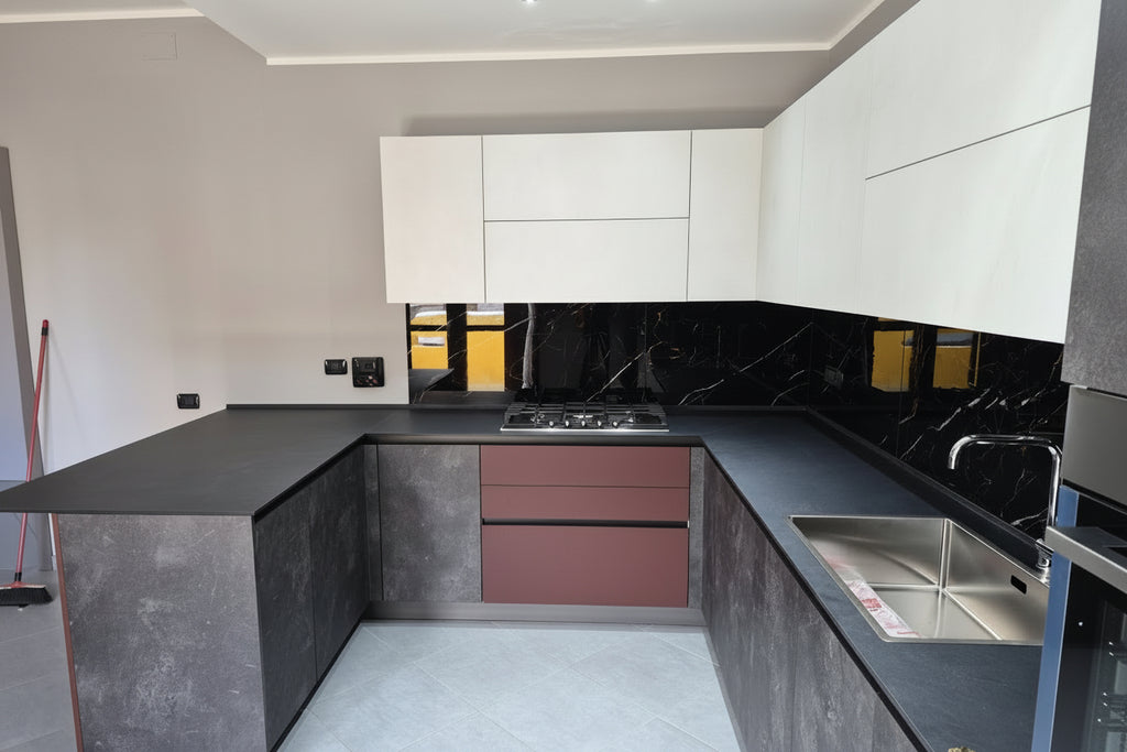 Composizione cucina cemento grigio/pensili bianchi opachi e elementi rosso Marsala con penisola snack