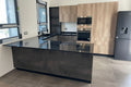 Composizione cucina angolare con colonne rovere naturale, boiserie stile Industrial e top in marmo nero