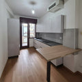 Cucina resina dust con piano Snack sagomato su misura con gambona in metallo scuro e parete colonne