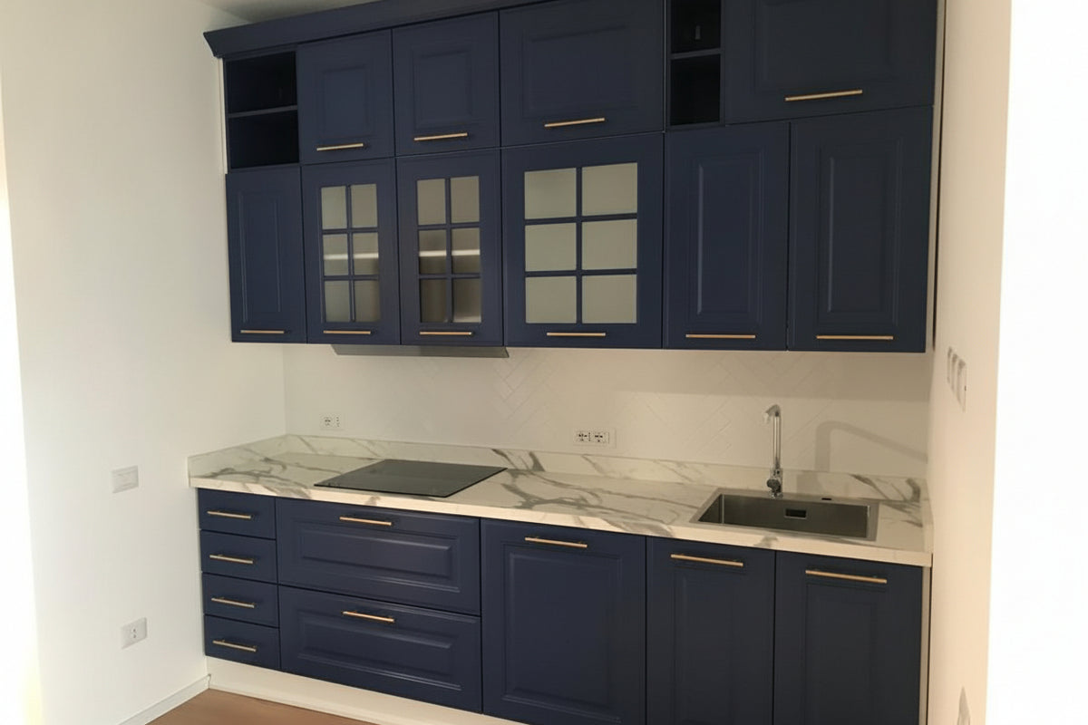 Composizione cucina classica con anta telaio laccata opaca blu, zoccoli in legno bianco e maniglie metallo champagne